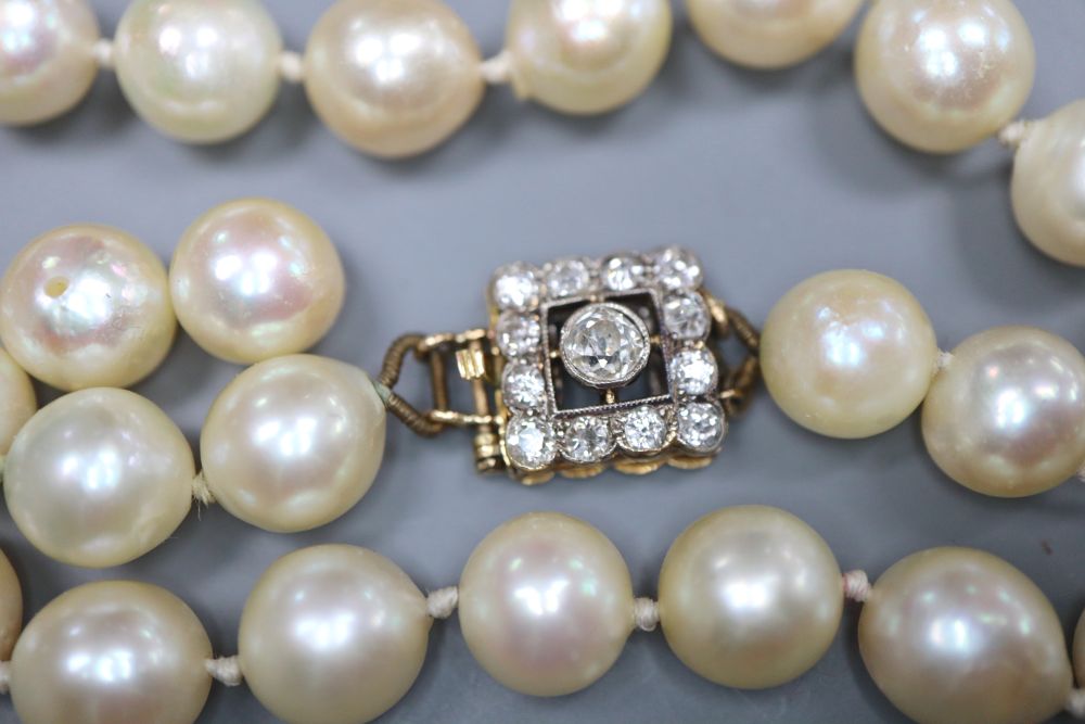 A single strand cultured pearl necklace, with yellow metal and thirteen stone diamond set clasp (strand a.f.).